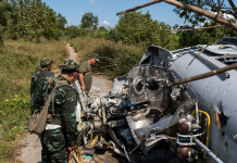 جنود جيش تحرير كارين الوطني (KNLA) ينظرون إلى مروحية محطمة في قاعدة ثين غان نيي ناونغ في نوفمبر 2024. تم إسقاط المروحية في يناير الماضي.